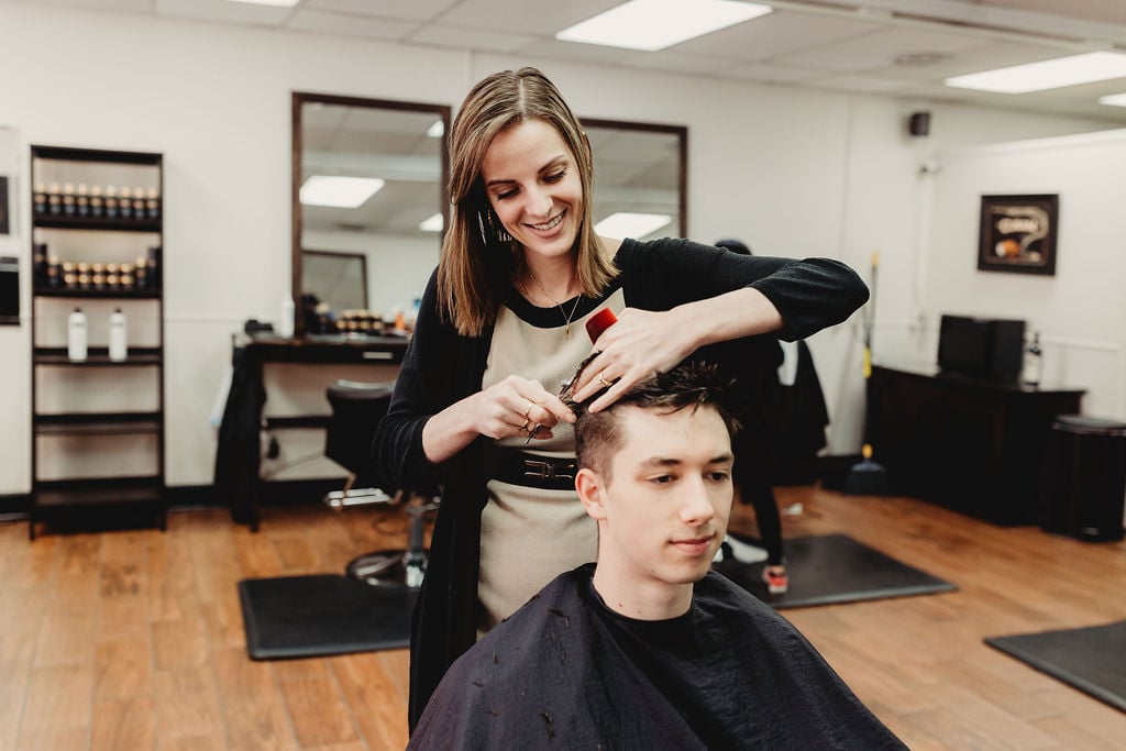 Stylist giving a scissor haircut at The Gentleman's Salon in State College, PA
